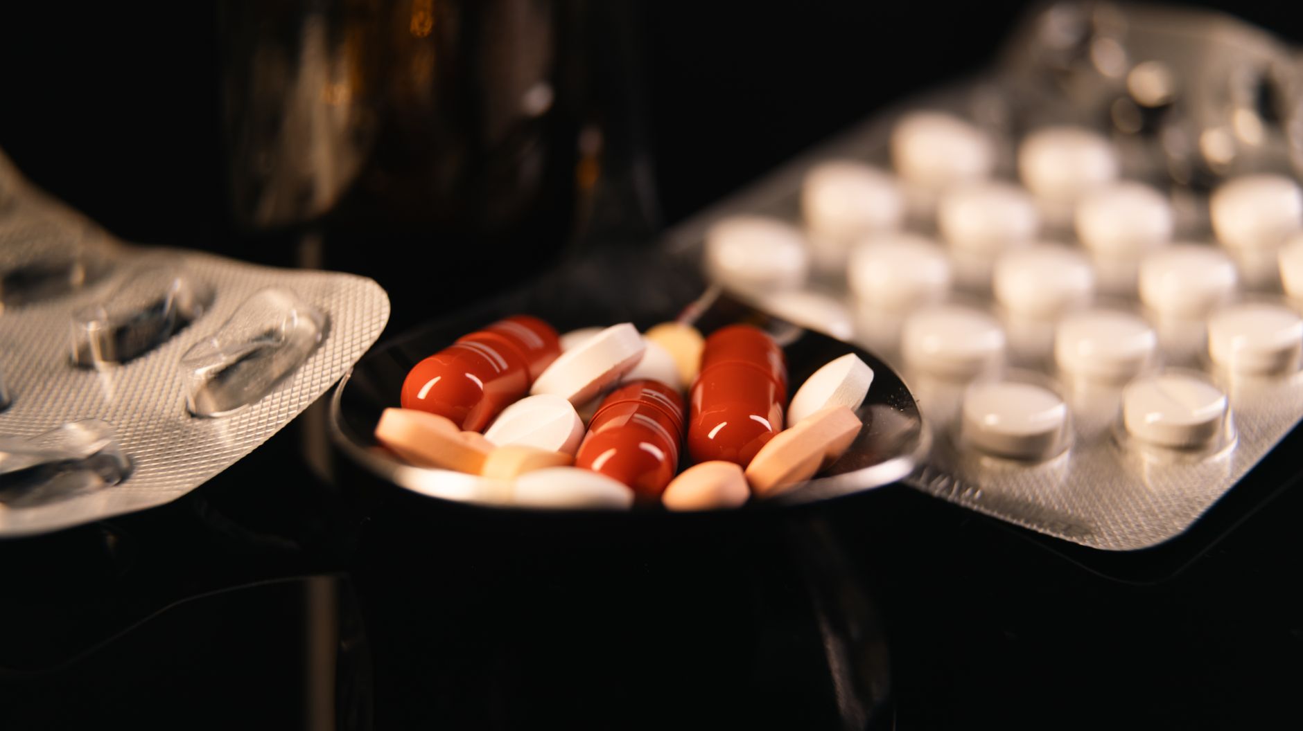 Farmacéutico atendiendo en mostrador con medicamentos y productos de parafarmacia