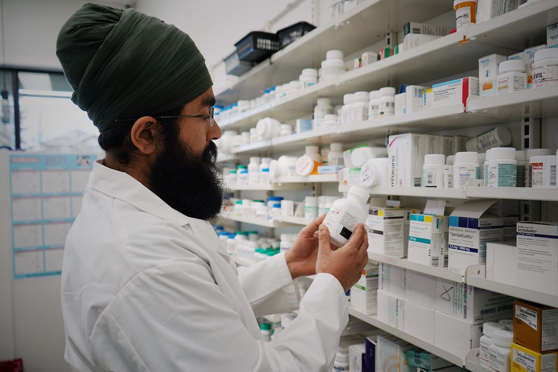 Farmacéutico dispensando medicación con receta en mostrador de farmacia
