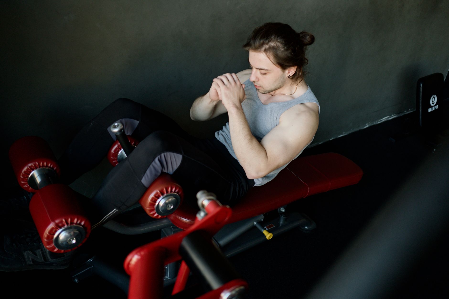 Persona entrenando en gimnasio con mancuernas y pesas