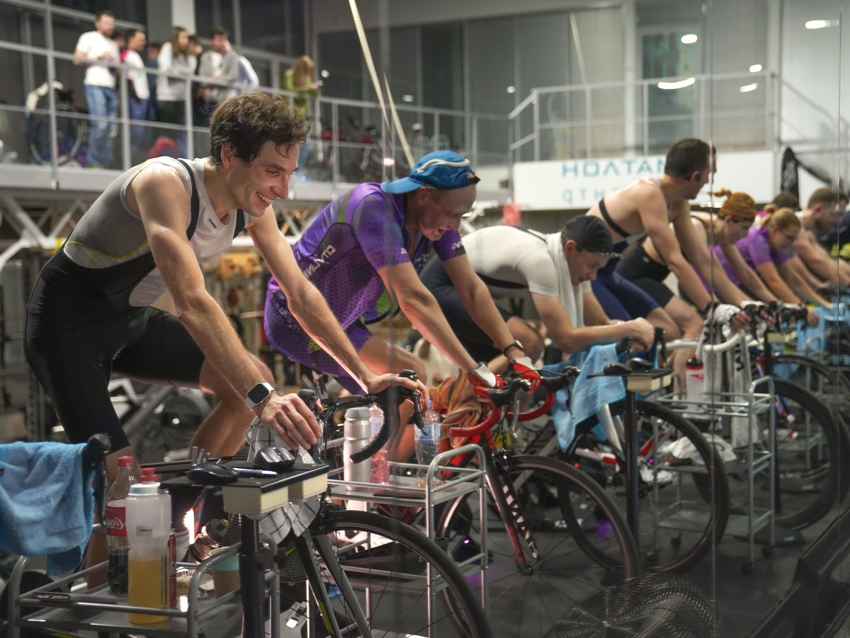 Clase colectiva de spinning en gimnasio con bicicletas estáticas