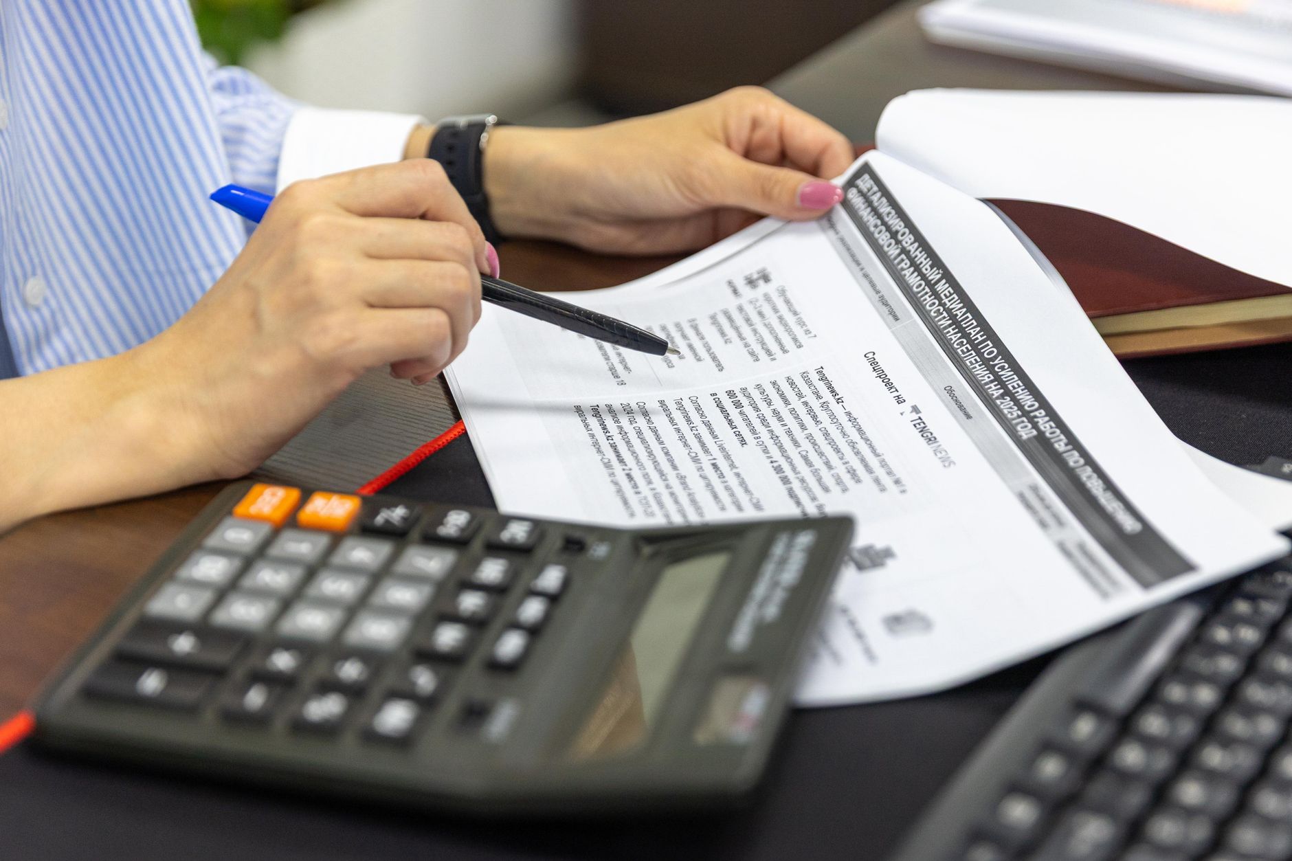 Contable revisando documentos fiscales con calculadora en oficina