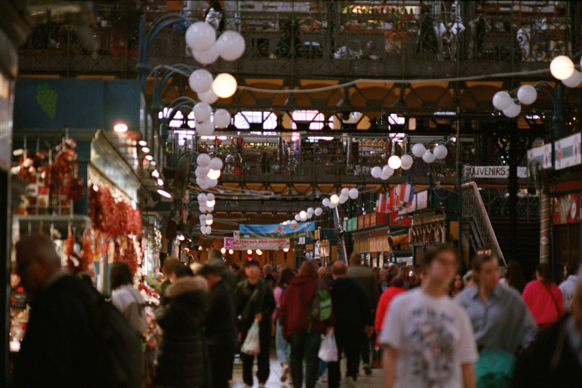 Interior de mercado municipal con compradores y puestos de productos frescos