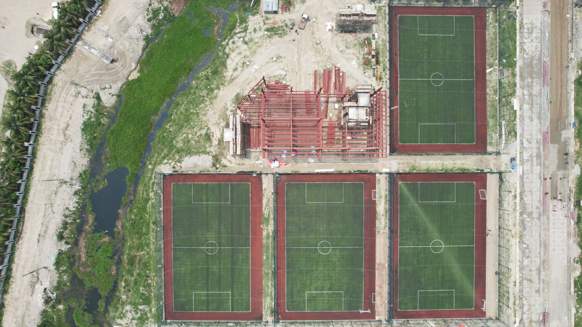 Campo de fútbol municipal con gradas y césped en ciudad española